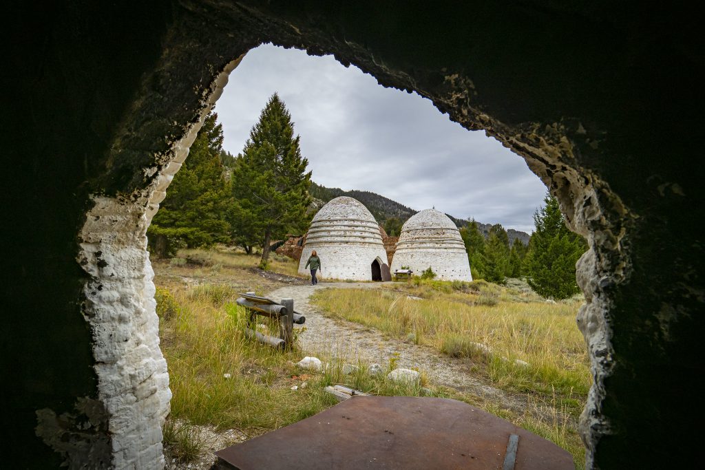 Two charcoal kilns viewed from the doorway of a third kiln
