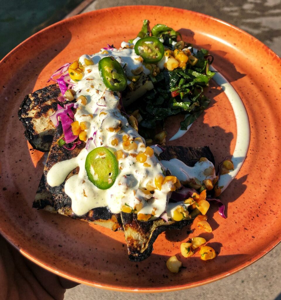 A delicious and colorful farm-to-table bowl from The 50 Mile Grill & Cafe at Norris Hot Springs. Norris Hot Springs' cafe is open year-round and offers a wide variety of food and drink.