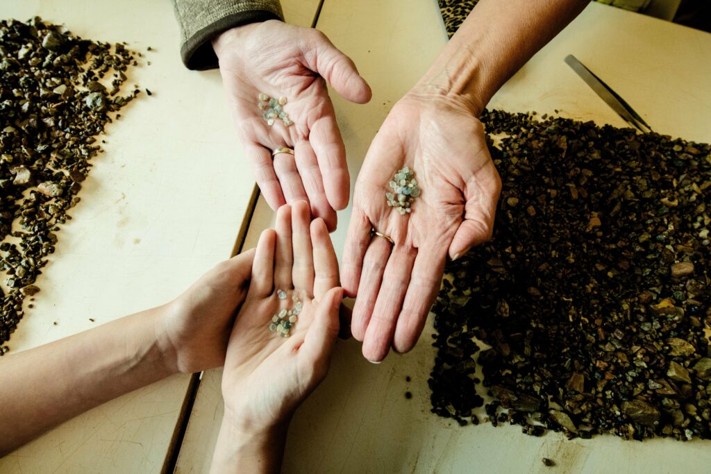 Hands showing a range of sizes and colors while panning for Montana sapphires in Philipsburg, Montana.