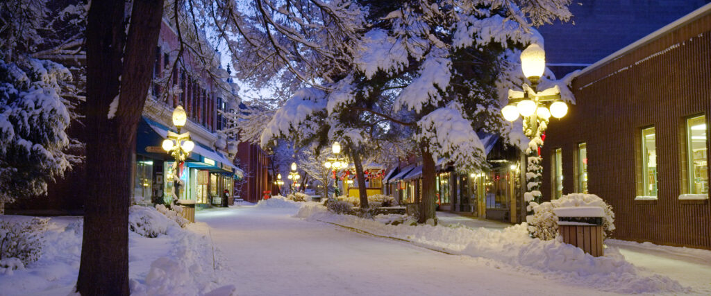 Downtown Helena walking mall at dusk with snow-covered trees, holiday lights, and shops along Last Chance Gulch in Montana. Photo by Mike Dreesman, Tempest Technologies.